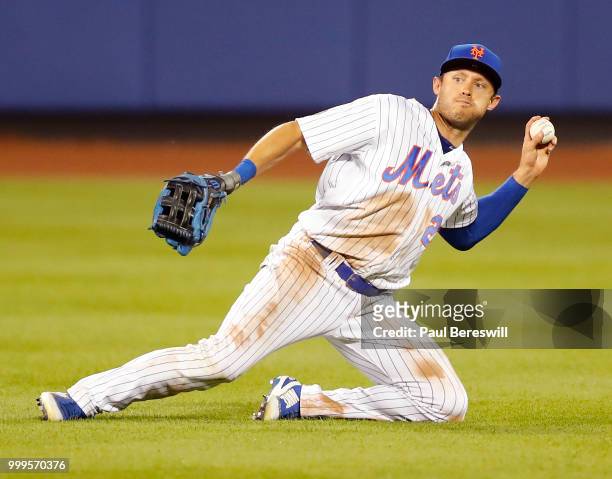 Matt den Dekker of the New York Mets throws the ball in after making a sliding catch on a fly ball hit to center by Jesmuel Valentin of the...