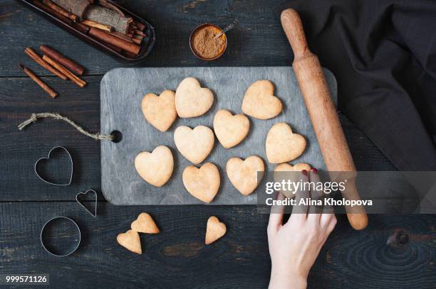 female hand holding the baked cookies-hearts - alina stockfoto's en -beelden