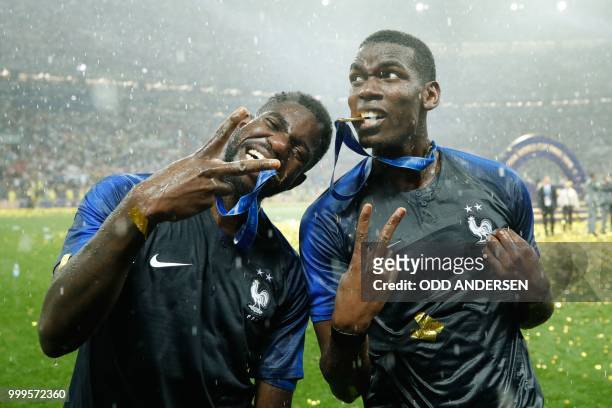 France's midfielder Paul Pogba and France's defender Samuel Umtiti celebrate with their medals after the Russia 2018 World Cup final football match...