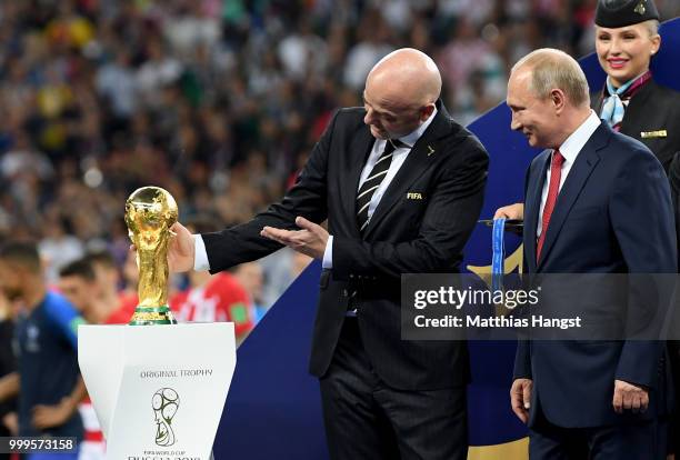President Gianni Infantino shows the World Cup trophy to President of Russia Vladimir Putin following the 2018 FIFA World Cup Final between France...