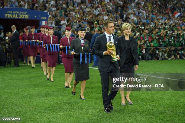 Former World cup winning captain Philipp Lahm of Germany carries the World Cup trophy onto the middle of the pitch for the winning ceremony following...