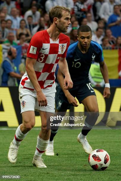 Ivan Strinic of Croatia is checked by Kylian Mbappe of France during the 2018 FIFA World Cup Russia Final between France and Croatia at Luzhniki...
