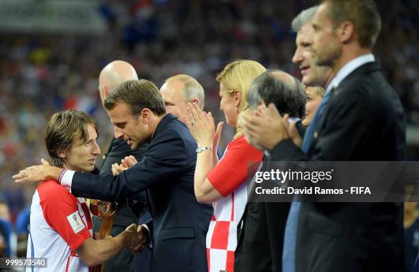 French President Emmanuel Macron embraces Luka Modric of Croatia as President of Croatia, Kolinda Grabar Kitarovic looks on during the 2018 FIFA...