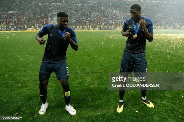 France's midfielder Paul Pogba and France's defender Samuel Umtiti celebrate after the Russia 2018 World Cup final football match between France and...