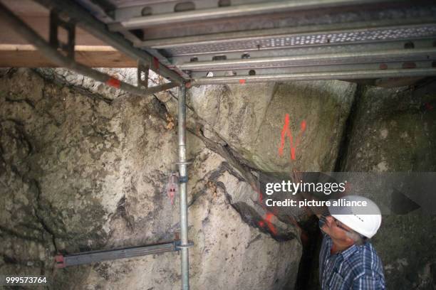 Project manager Manfred Fischer looks at fissures in the rock of the Drachenfels in Koenigswinter, Germany, 30 August 2017. The Drachenfels is a...