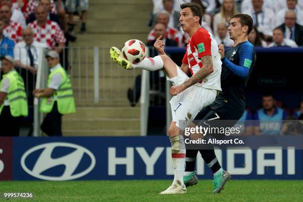 Mario Mandzukic of Croatia competes for the ball with Antoine Griezmann of France during the 2018 FIFA World Cup Russia Final between France and...