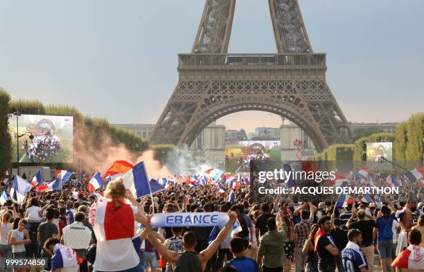 People gather on the fan zone to watch the Russia 2018 World Cup final football match between France and Croatia, on the Champ de Mars in Paris on...