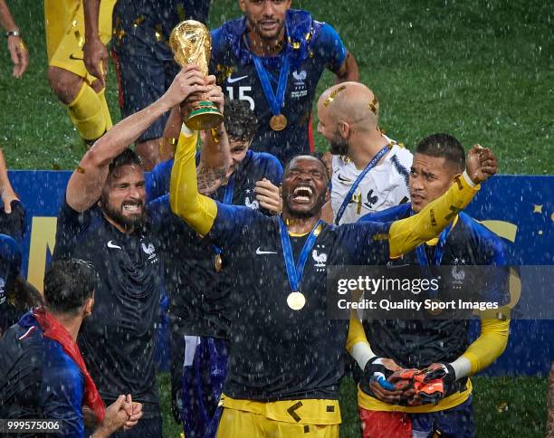 Steve Mandanda of France celebrates with the trophy with his teammates after the 2018 FIFA World Cup Russia Final between France and Croatia at...