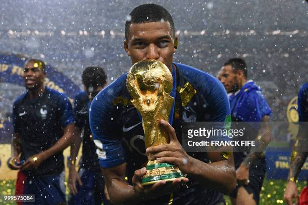 France's forward Kylian Mbappe kisses the World Cup trophy after winning the Russia 2018 World Cup final football match between France and Croatia at...