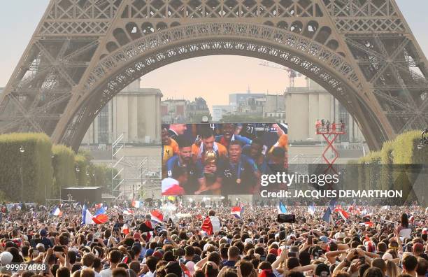 People gather on the fan zone to watch the Russia 2018 World Cup final football match between France and Croatia, on the Champ de Mars in Paris on...