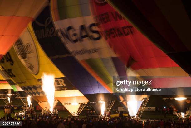 Hot air baloons during hte so-called Night-Glow event on the opening evening of the 27th Warsteiner International Montgolfiade in Warstein, Germany,...