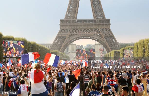 People gather on the fan zone to watch the Russia 2018 World Cup final football match between France and Croatia, on the Champ de Mars in Paris on...