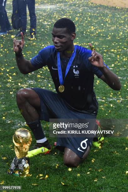 France's midfielder Paul Pogba celebrates with the trophy at the end of the Russia 2018 World Cup final football match between France and Croatia at...