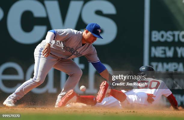 Mookie Betts of the Boston Red Sox steal second base as Aledmys Diaz of the Toronto Blue Jays has trouble handling the throw in the seventh inning at...