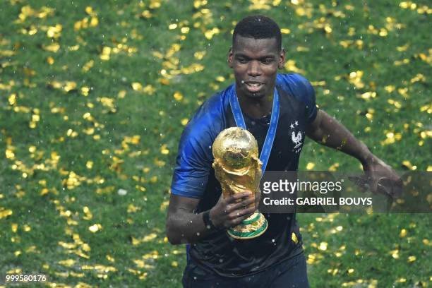France's midfielder Paul Pogba holds the trophy as he celebrates during the trophy ceremony after winning the Russia 2018 World Cup final football...