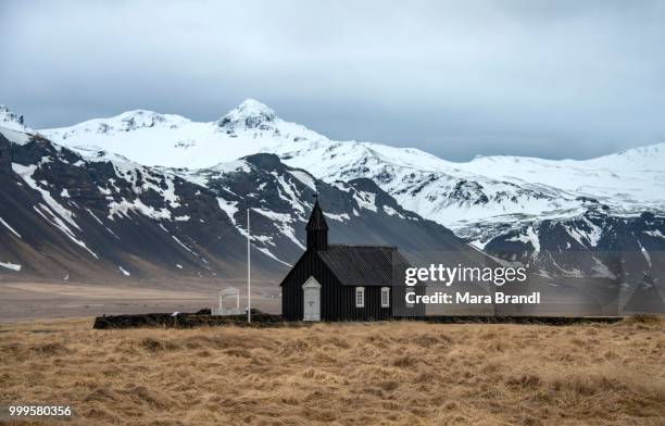 budakirkja church in front of snow-covered mountains, vesturland, west iceland, iceland - west central iceland stock pictures, royalty-free photos & images