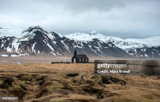 budakirkja church in front of snow-covered mountains, vesturland, west iceland, iceland - islande du centre ouest photos et images de collection