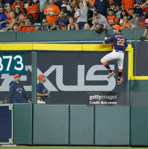 Josh Reddick of the Houston Astros scales the right field wall but unable to make a play on a home run by Jeimer Candelario of the Detroit Tigers in...