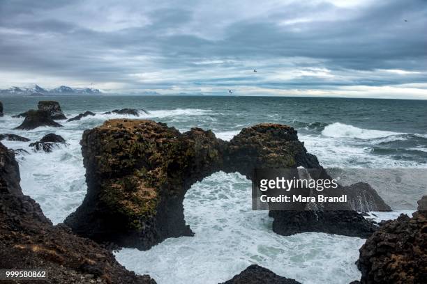 gat velcro, arch in the sea, waves at the sea, bad weather, west iceland, iceland - west central iceland stock pictures, royalty-free photos & images