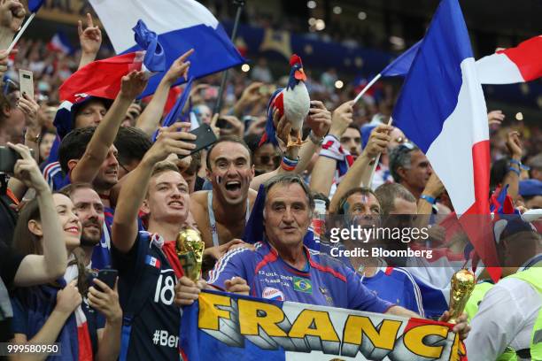 Supporters of the France team cheer and wave French national flags after France beat Croatia in the FIFA World Cup final match in Moscow, Russia, on...