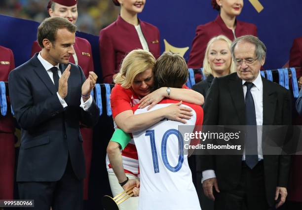 Kolinda Grabar Kitarovic, Croatia's president, center, embraces Luka Modric of Croatia as Emmanuel Macron, France's president, left, applauds during...