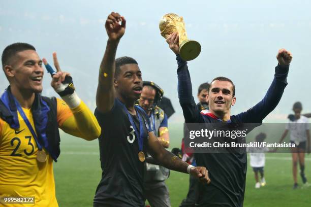 Antoine Griezmann of France celebrates with teammates Presnel Kimpembe and Alphonse Areola after the 2018 FIFA World Cup Russia Final between France...