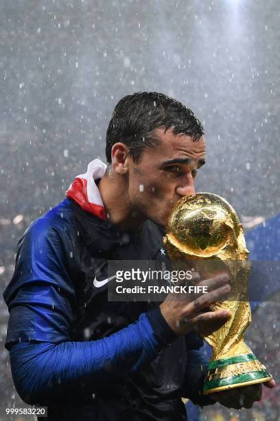 France's forward Antoine Griezmann kisses the World Cup trophy during the trophy ceremony at the end of the Russia 2018 World Cup final football...