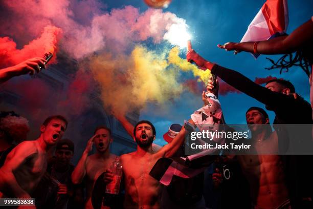 French football fans celebrate with smoke grenades in front of the Arc de Triomph after France's victory against Croatia in the World Cup Final on...