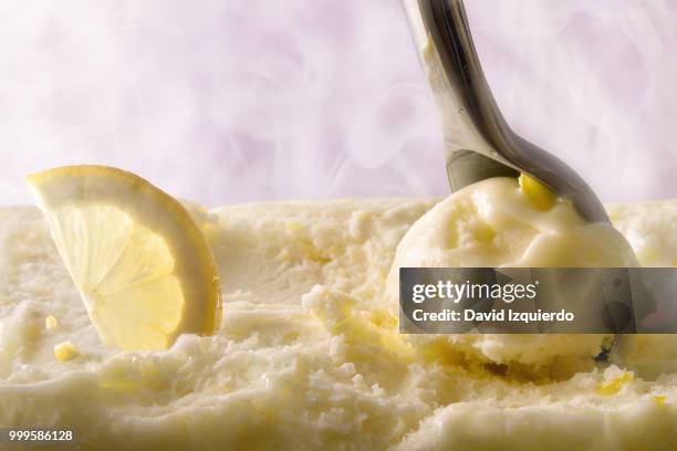 making lemon ice cream ball with scoop front view - orange sorbet stock pictures, royalty-free photos & images