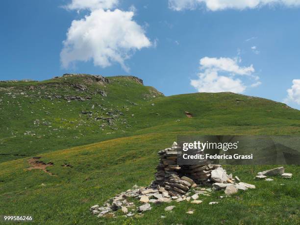 rock cairn on a green pasture on mount teggiolo, cairasca valley - ヴェルバーノ・クジオ・オッソラ県 ストックフォトと画像