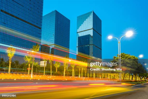 light trails and office buildings at night - wu stock-fotos und bilder