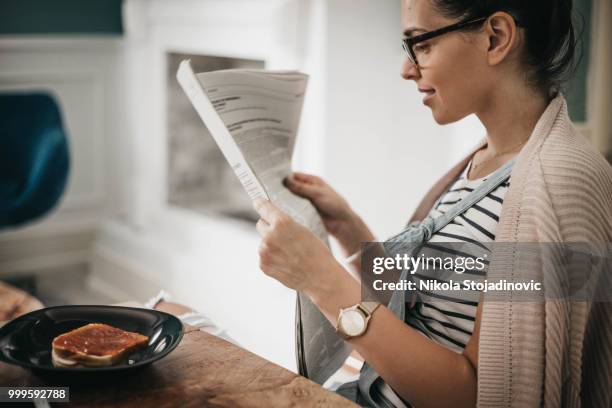 bella mujer comiendo un bocadillo saludable y leyendo periódico - nikla fotografías e imágenes de stock