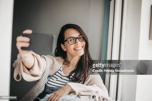 chica en casa tomando selfie - nikla fotografías e imágenes de stock