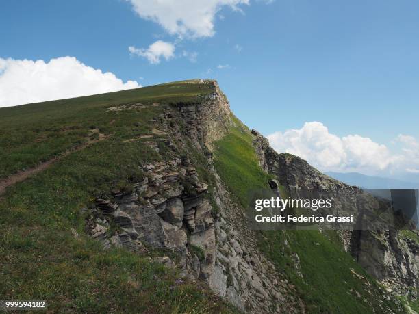 motocross on a hiking trail on monte teggiolo (tiny figure) - fmx stock pictures, royalty-free photos & images