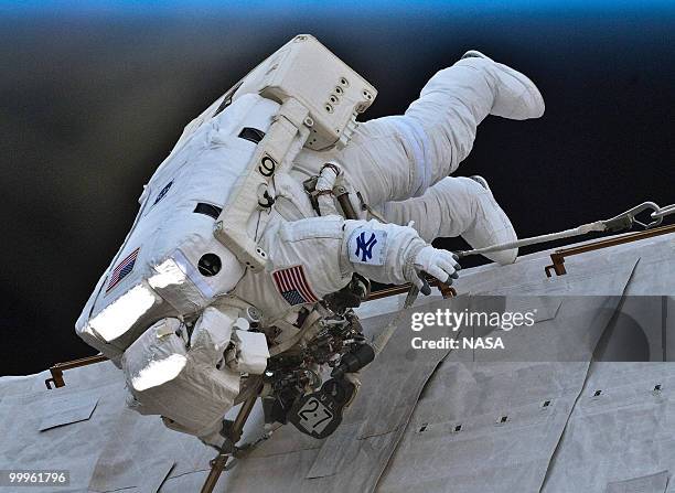 In this handout image provided by NASA, NASA astronaut Garrett Reisman, STS-132 mission specialist, wears a New York Yankee symbol on his instruction...