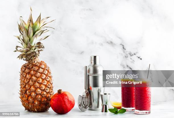 mixing tequila sunrise in a shaker on a marble table from pineap - tequila sunrise stock pictures, royalty-free photos & images