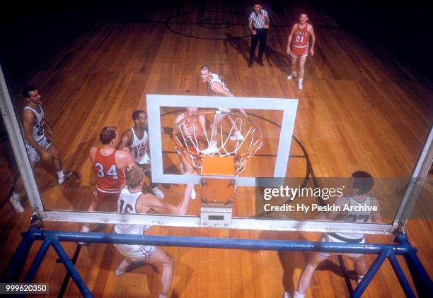 Slater Martin of the St. Louis Hawks drives to the basket as Si Green and Jack Parr of the Cincinnati Royals defend during an NBA game on November 2,...