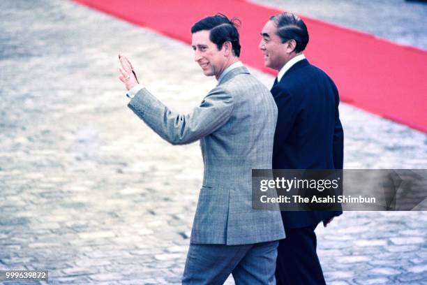 Prince Charles, Prince of Wales waves to well-wishers after reviewing the honour guard with Japanese Prime Minister Yasuhiro Nakasone during the...