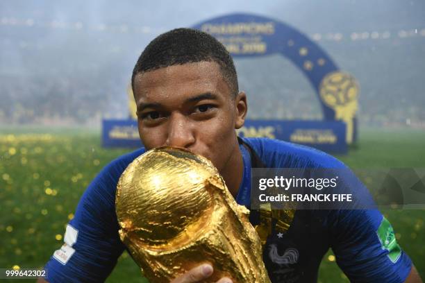 France's forward Kylian Mbappe kisses the World Cup trophy after the Russia 2018 World Cup final football match between France and Croatia at the...