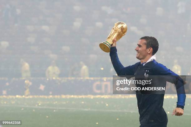 France's forward Antoine Griezmann celebrates with the World Cup trophy after the Russia 2018 World Cup final football match between France and...