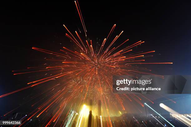 Viewers watch the beginning of the Pyronale fireworks competition at the Olympic Stadium in Berlin, Germany, 01 September 2017. Photo: Paul Zinken/dpa