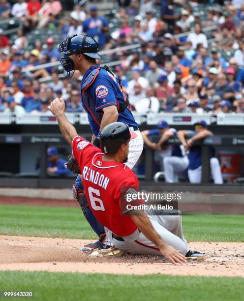 Anthony Rendon of the Washington Nationals scores against Devin Mesoraco of the New York Mets in the seventh innng during their game at Citi Field on...