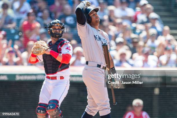 Catcher Yan Gomes of the Cleveland Indians returns the ball as Aaron Hicks of the New York Yankees reacts after striking out to end the top of the...