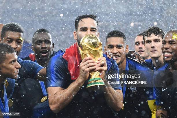 France's defender Adil Rami kisses their World Cup trophy as they celebrate their win at the end of the Russia 2018 World Cup final football match...