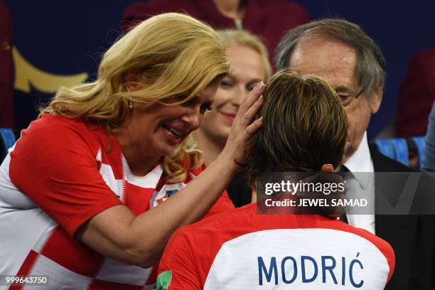 Croatian President Kolinda Grabar-Kitarovic embraces Croatia's midfielder Luka Modric on the stage at the end of the Russia 2018 World Cup final...