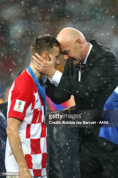 President Gianni Infantino embraces Ivan Rakitic of Croatia at the trophy presentation at the end of the 2018 FIFA World Cup Russia Final between...