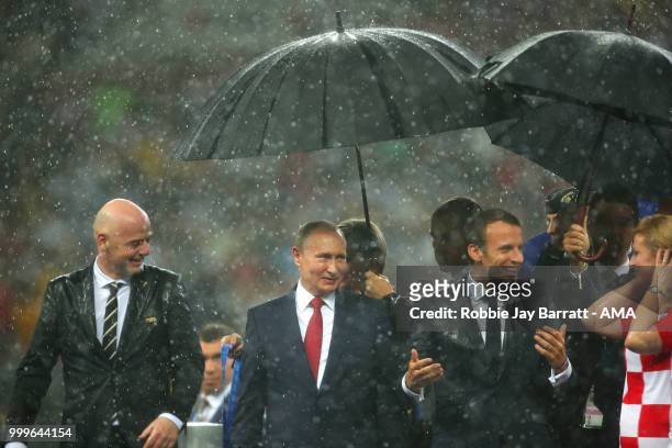 President Gianni Infantino, Russia's President Vladimir Putin, and France's President Emmanuel Macron look on at the trophy presentation at the end...