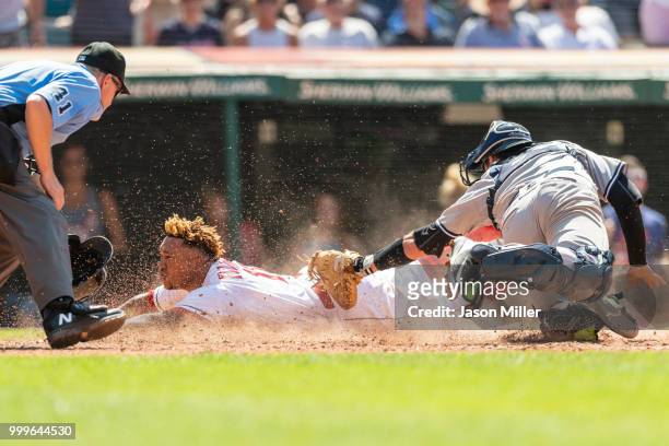 Home plate umpire Jerry Meals watches as Jose Ramirez of the Cleveland Indians scores wile catcher Kyle Higashioka of the New York Yankees tries to...