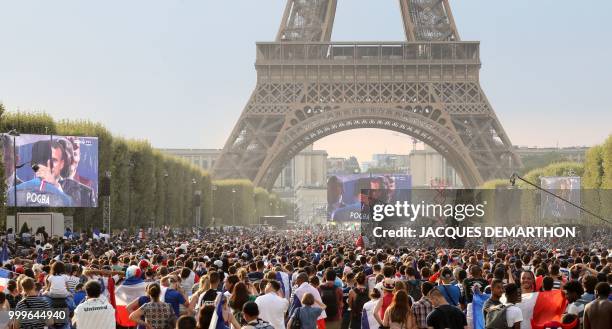 People celebrate in the fan zone the Russia 2018 World Cup final victory football match between France and Croatia, on the Champ de Mars in Paris on...