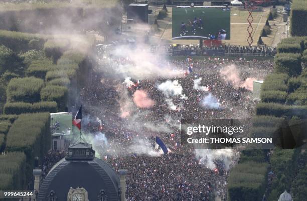 This picture taken from the panoramic observatory of the Montparnasse Tower shows people reacting in the fan zone on the Champs de Mars after France...